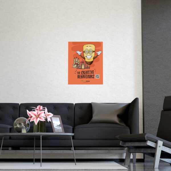 A modern living room with a black sofa, glass coffee table with pink lilies, and a black lounge chair. Above the sofa hangs the colorful Spark Poster: Light Up the Room (and your Creativity) featuring a smiling yellow character.